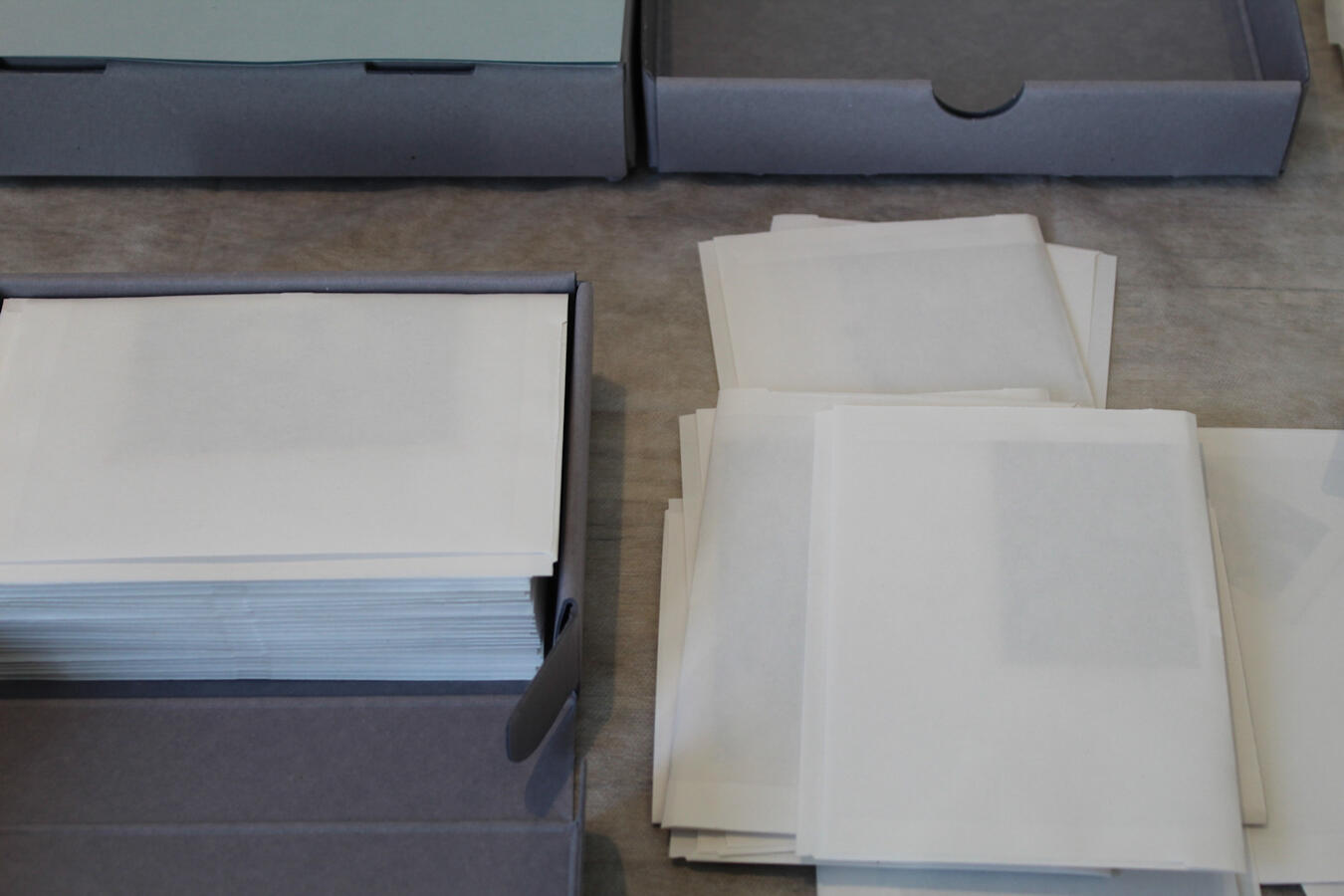 In dem Bild sind geöffnete Archivboxen mit vielen weißen Umschlägen ordentlich gestapelt. In dem Bild sind geöffnete Archivboxen mit vielen weißen Umschlägen ordentlich gestapelt.